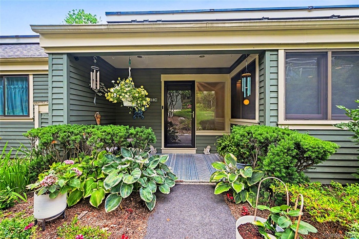 Front covered entry porch with beautiful plantings.