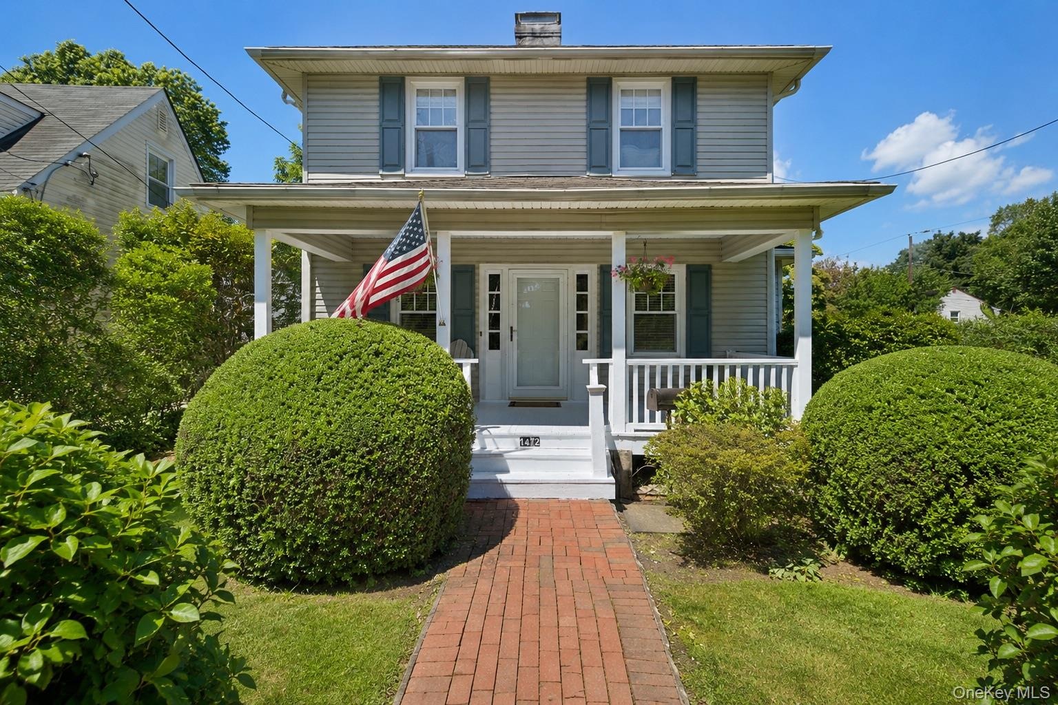 Two-story residence featuring  welcoming covered front porch
