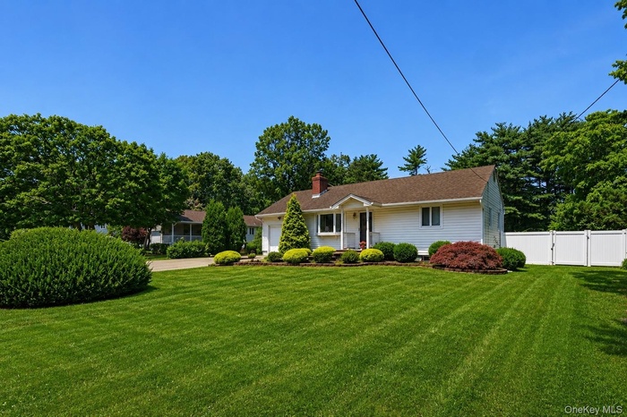 Single-story residence featuring white siding and a brown shingle roof