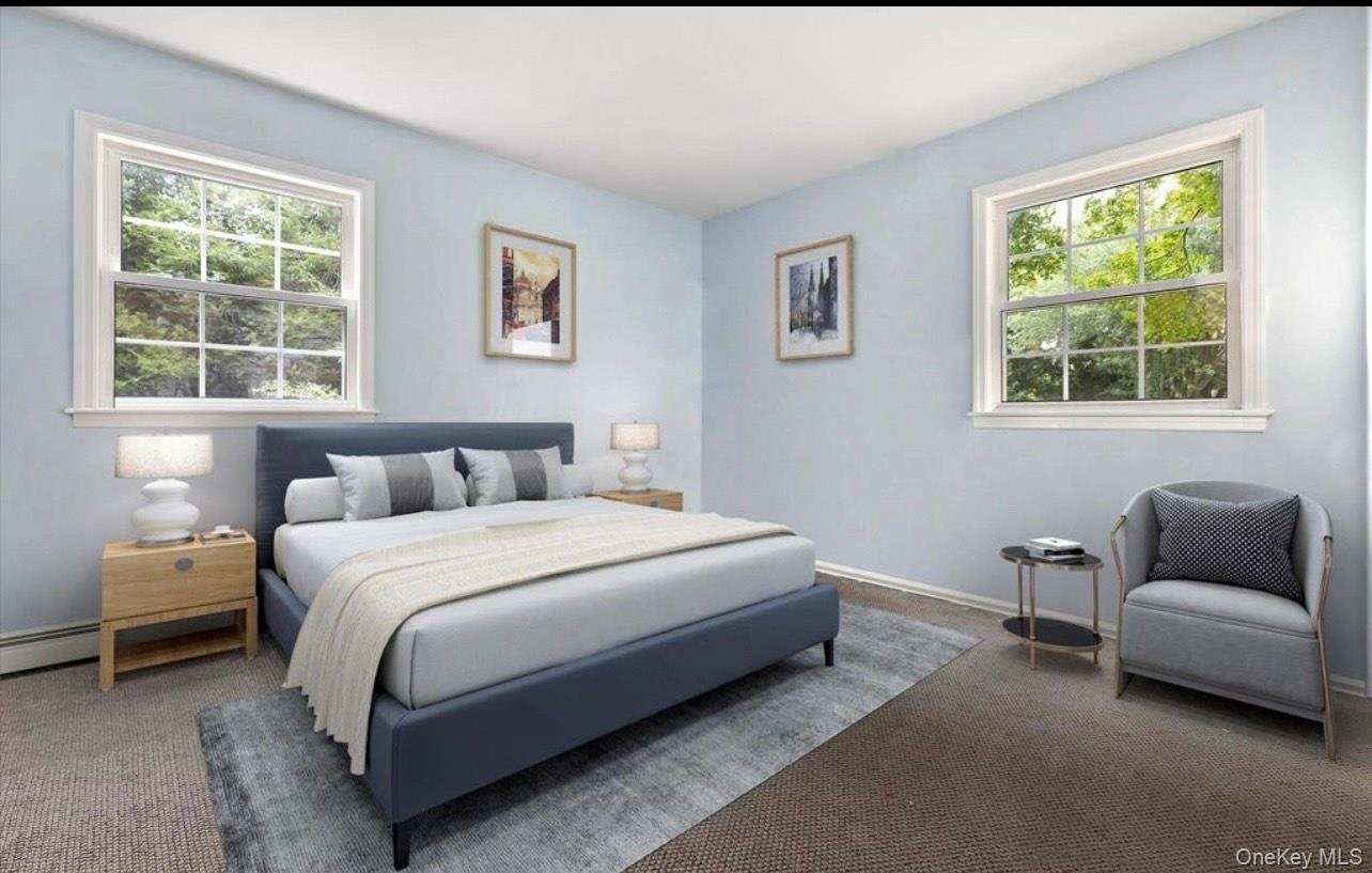 Carpeted bedroom featuring multiple windows