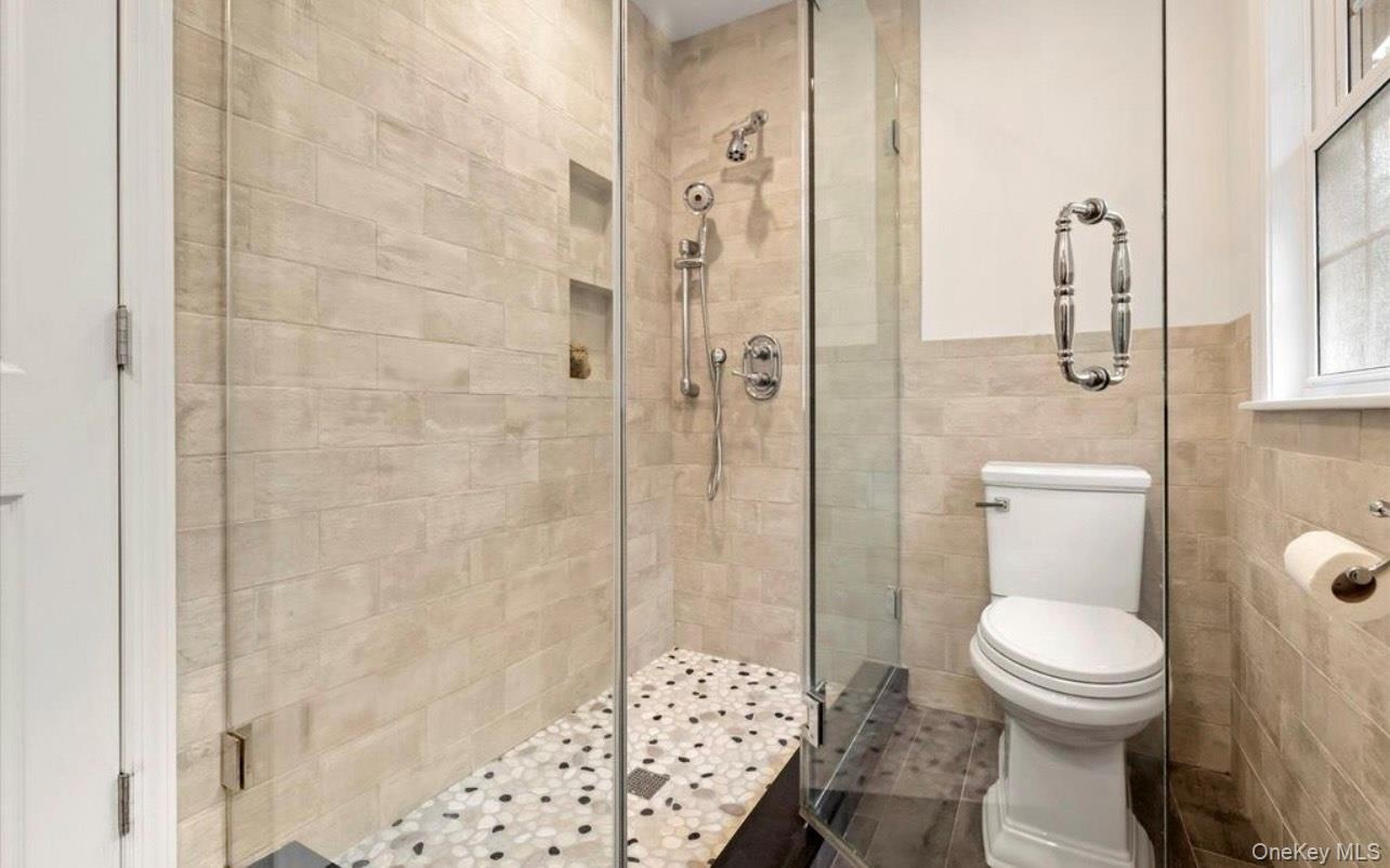 Full bath with a stall shower and tile walls