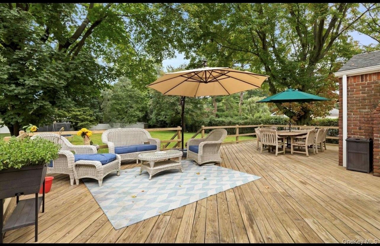Deck with outdoor dining area, an outdoor living space, and view of wooded area