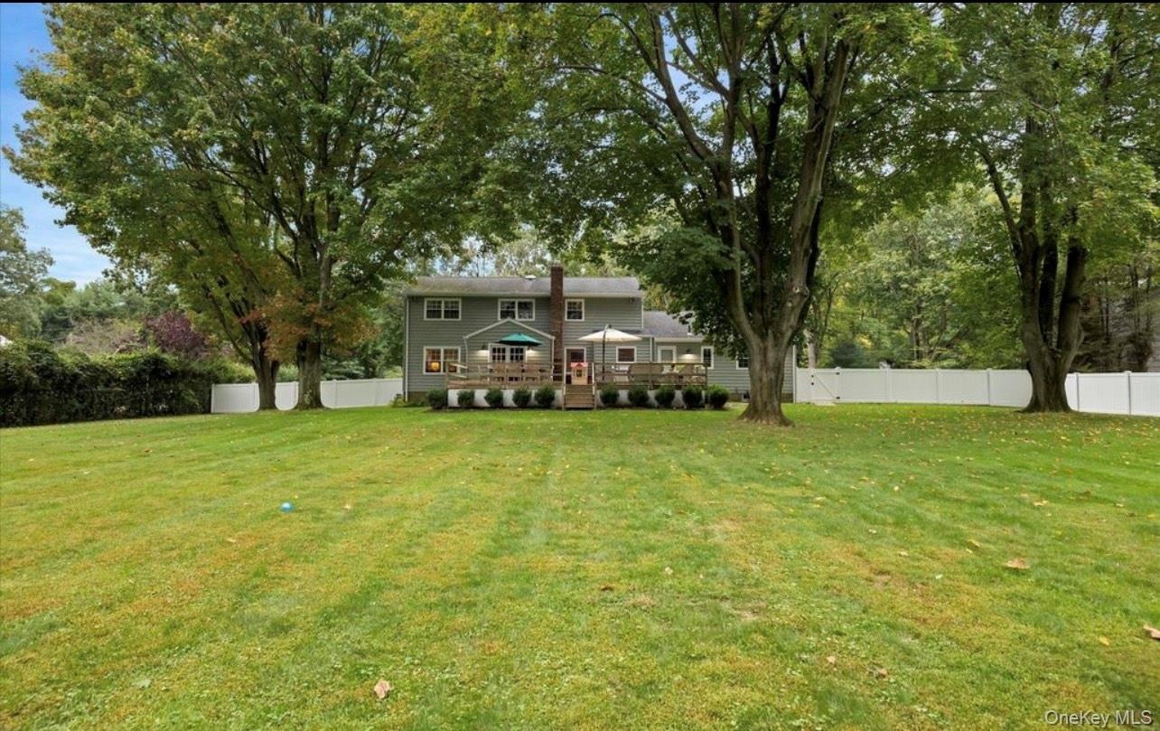 View of yard featuring a deck and view of scattered trees