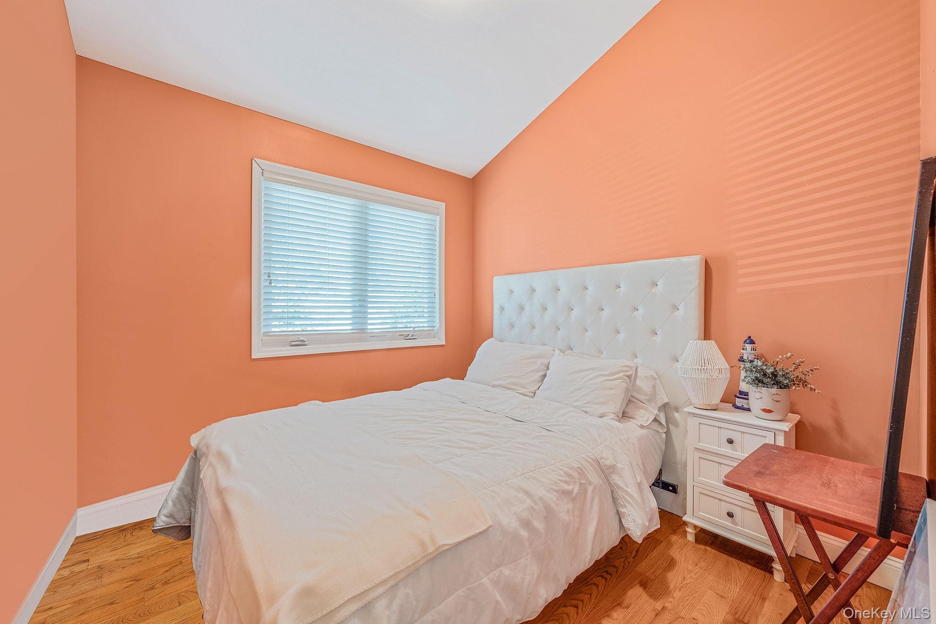 Bedroom with light wood-style floors and lofted ceiling