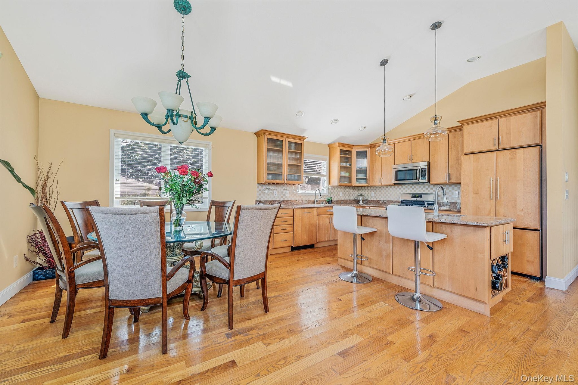 Dining space featuring lofted ceiling, light wood-style floors, and a chandelier