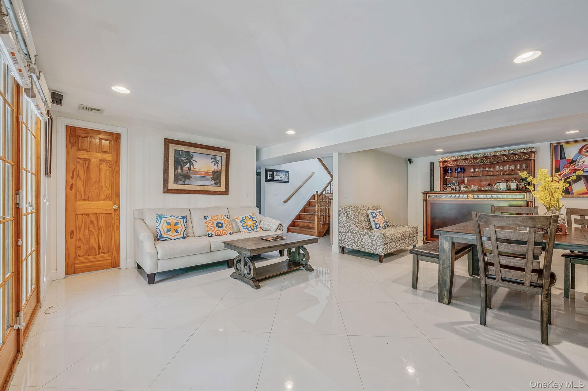 Living room with recessed lighting, light tile patterned flooring, and stairs