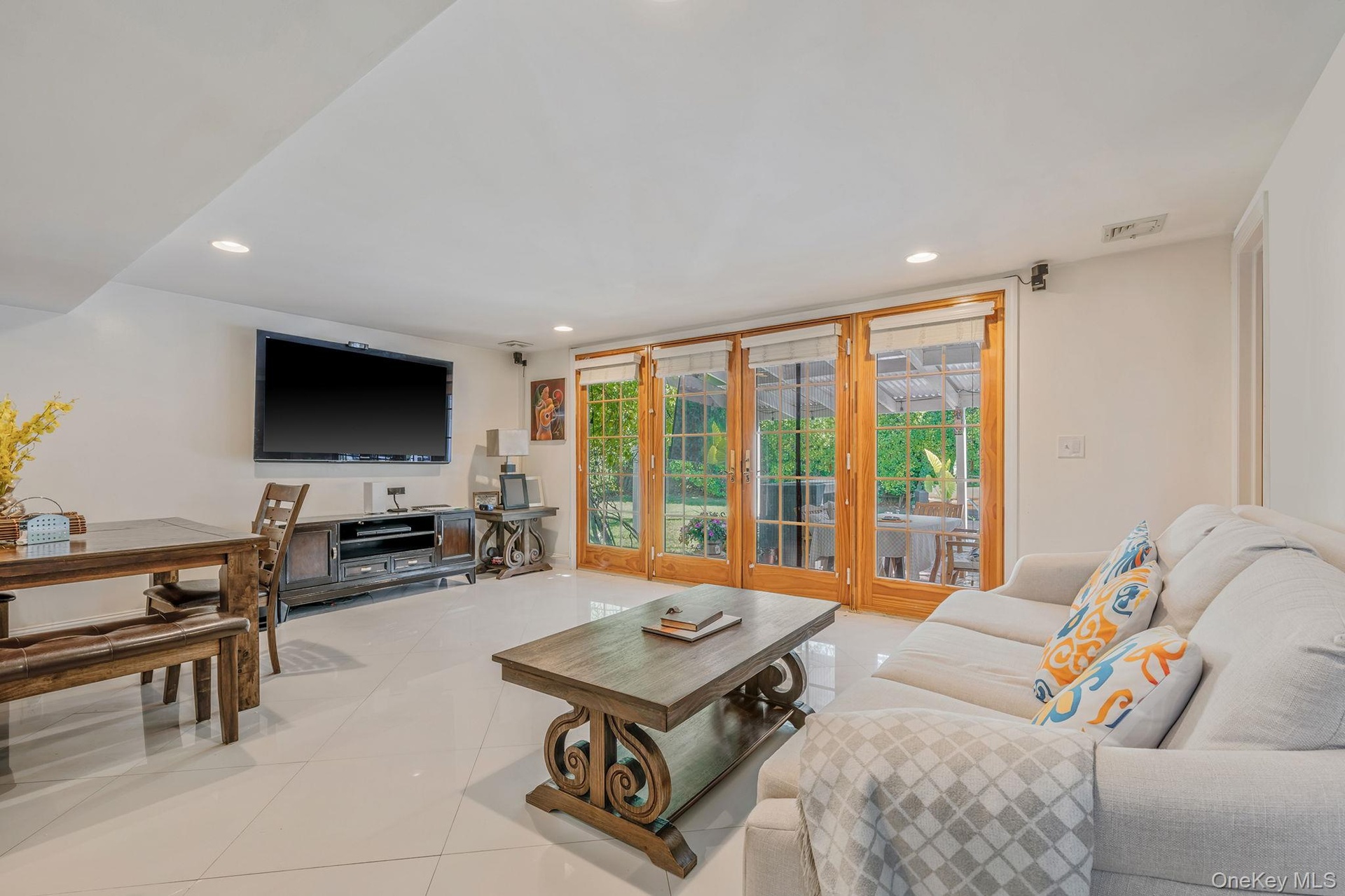 Living room with light tile patterned floors and recessed lighting