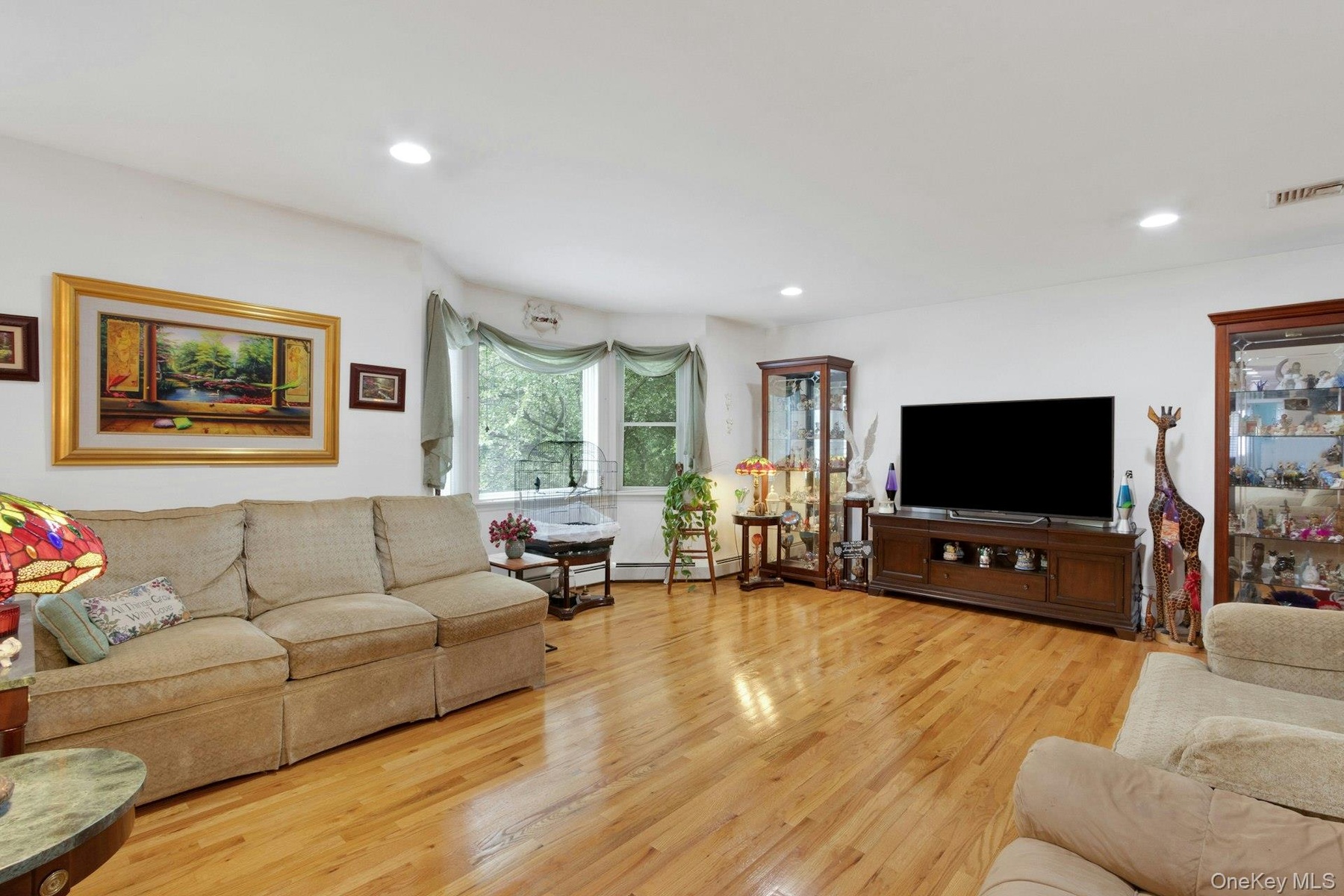 Living room with hardwood floors, recessed lighting, sunlight