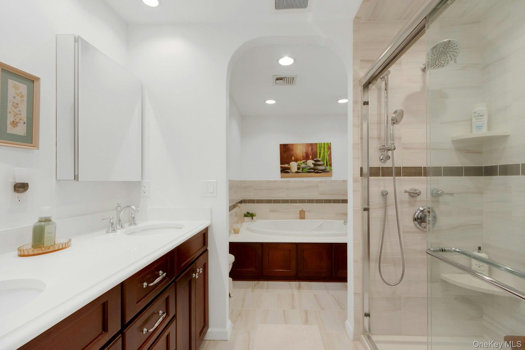 Luxurious updated ensuite bathroom with a double vanity, walk-in shower, large jacuzzi soaking tub