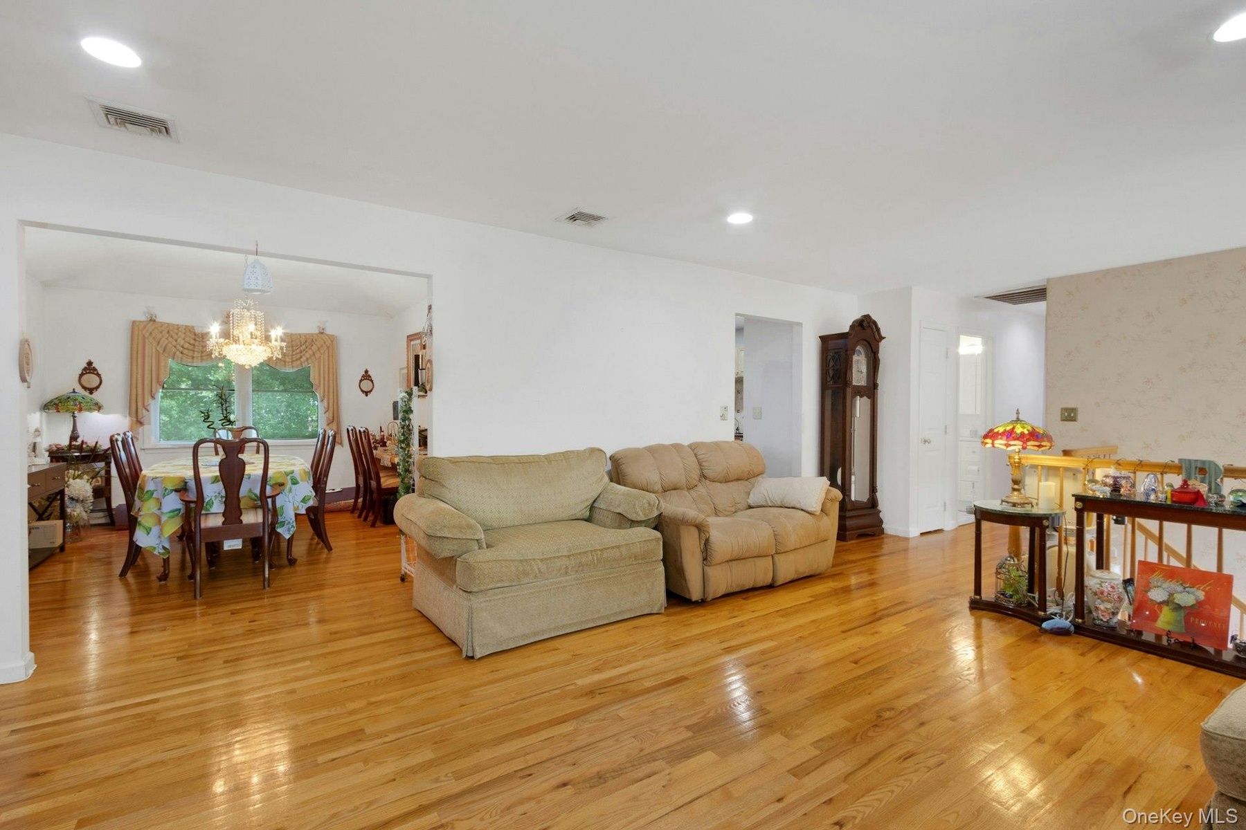 Living room open layout to dining room, hardwood floors, recessed lighting, sunlight