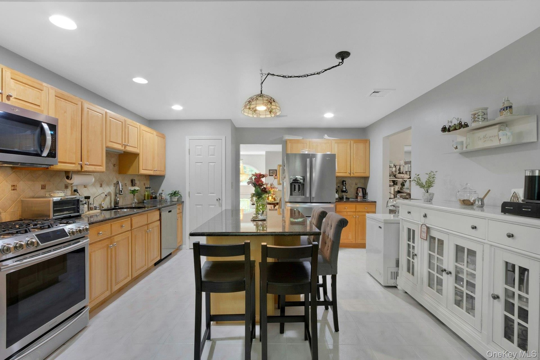 Kitchen with movable island, stainless appliances, recessed lighting