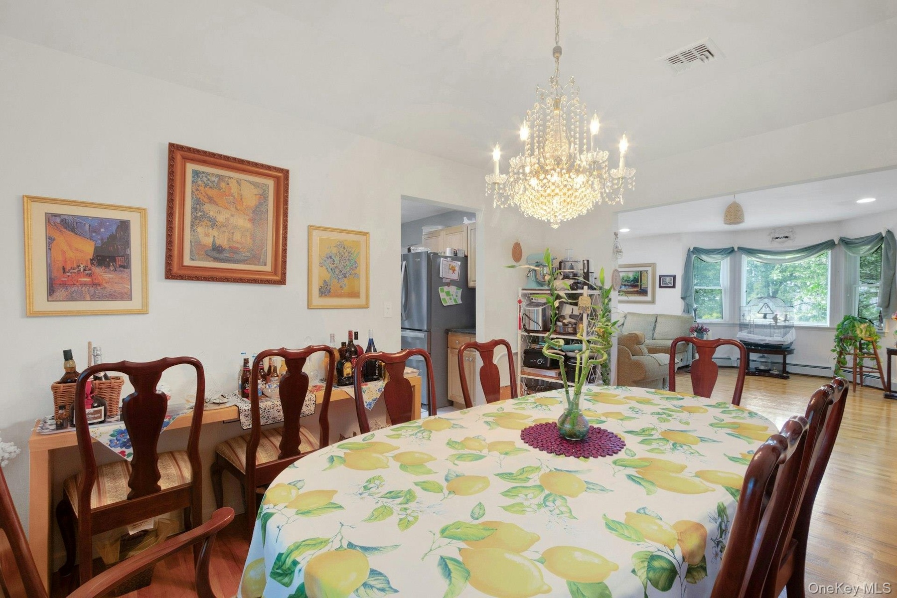 Dining room open to living room with hardwood floors and plenty of sunlight