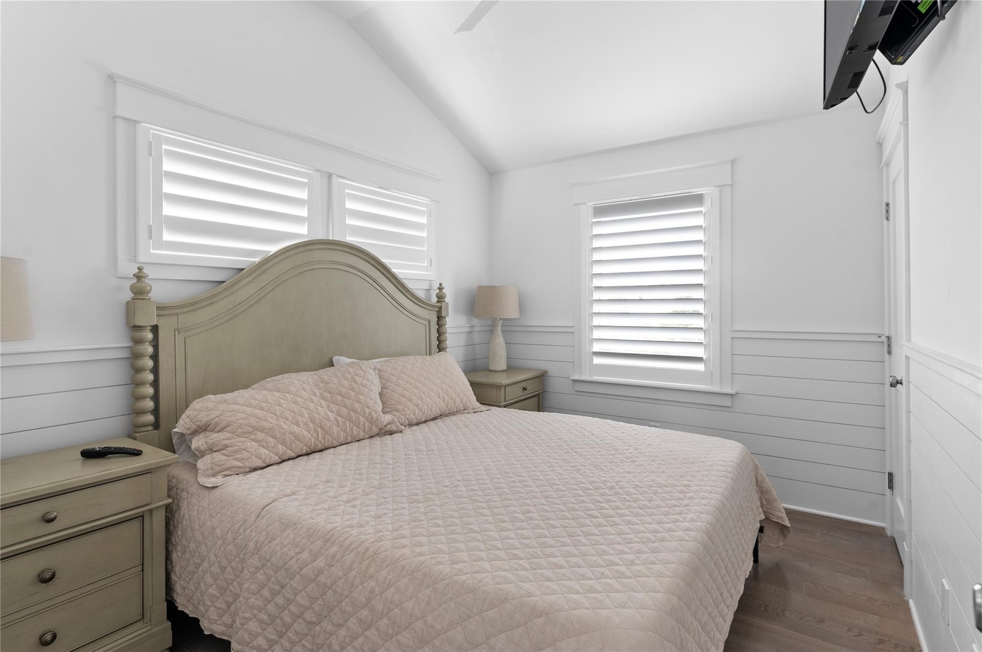 Bedroom with dark wood-type flooring, vaulted ceiling, and ceiling fan