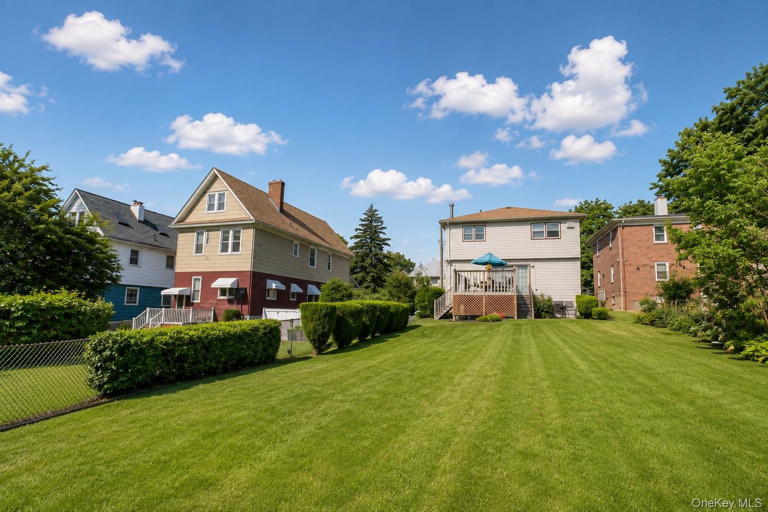 Expansive green lawn with mature perimeter hedging