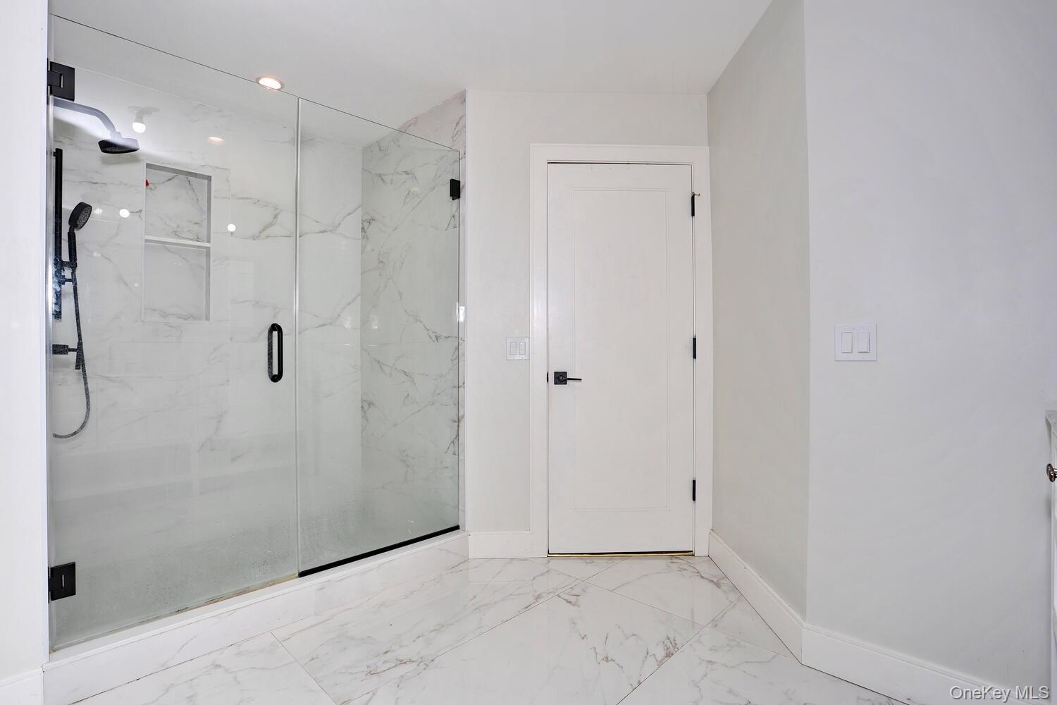 Bathroom with marble finish flooring, a marble finish shower, and recessed lighting