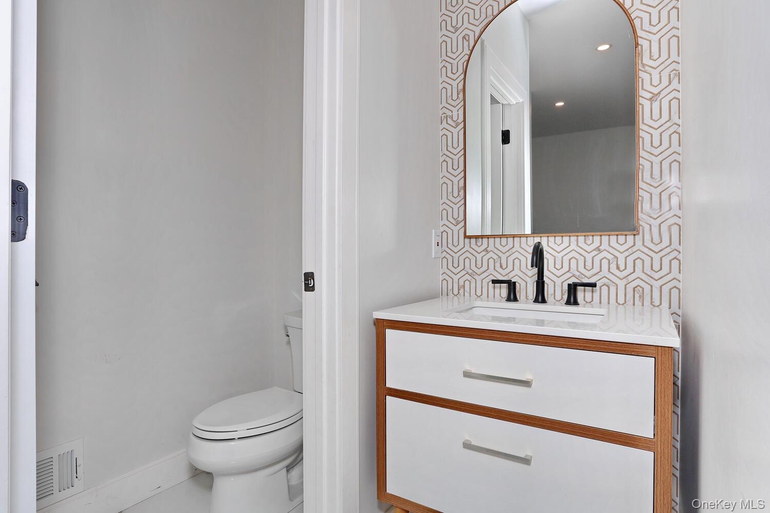 Bathroom with vanity and tasteful backsplash