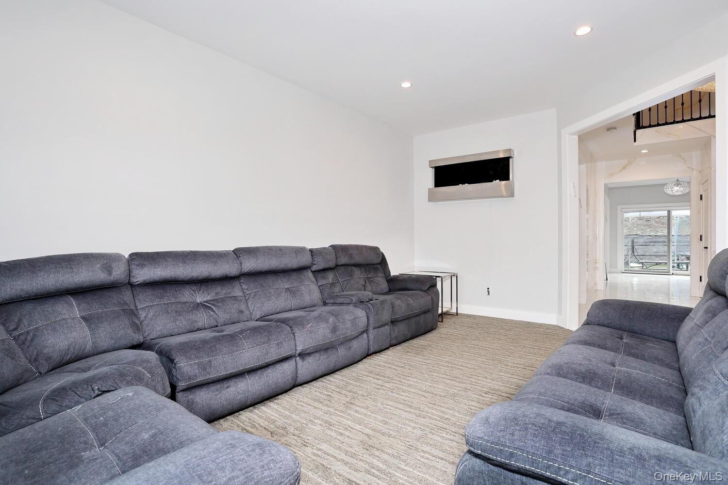 Living area with recessed lighting and carpet floors