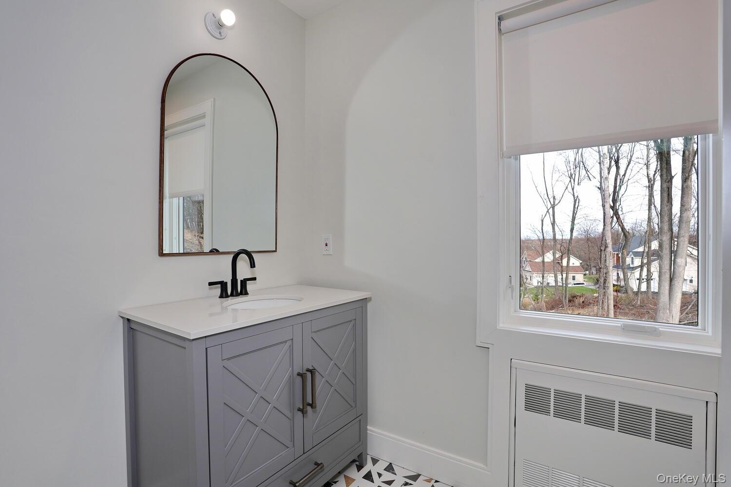 Bathroom featuring radiator, vanity, and a residential view