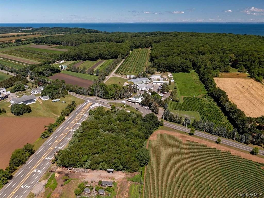 View of property location featuring large plots for crops, rural landscape, and a nearby body of water