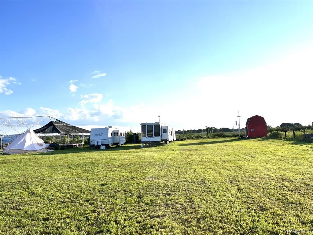 View of grassy yard featuring an outbuilding