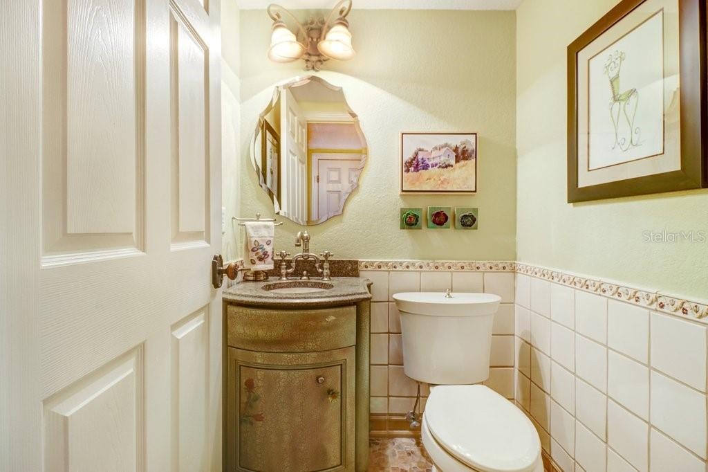 Charming custom 1/2 bath off kitchen with river rock floor tile.
