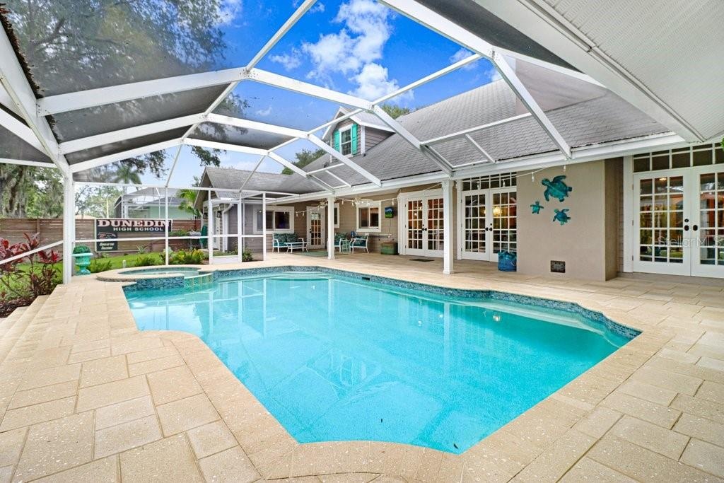 Custom shaped pool with swim seat, spa with spillover ledge feature.