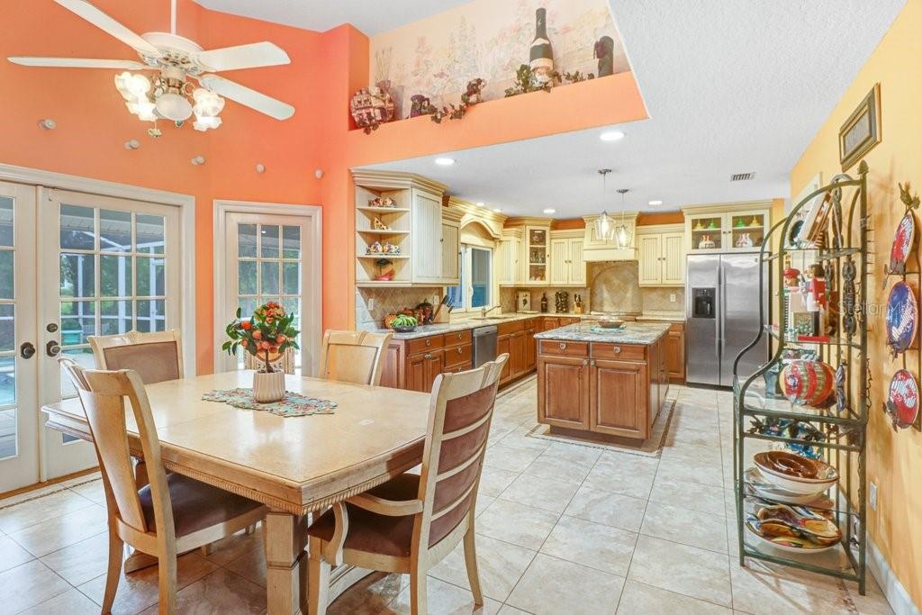 Large Eat-in Kitchen with French doors leading out to pool/patio area with vaulted ceilings.
