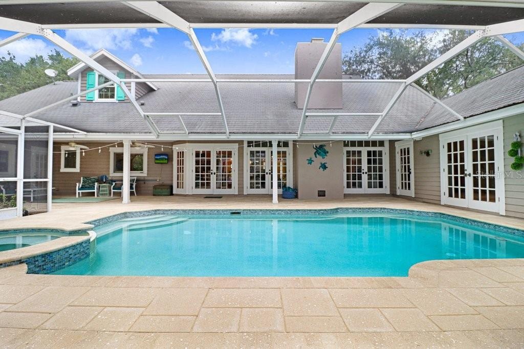 Pool/Spa view showcasing wrap around Hacienda floor plan with French doors.