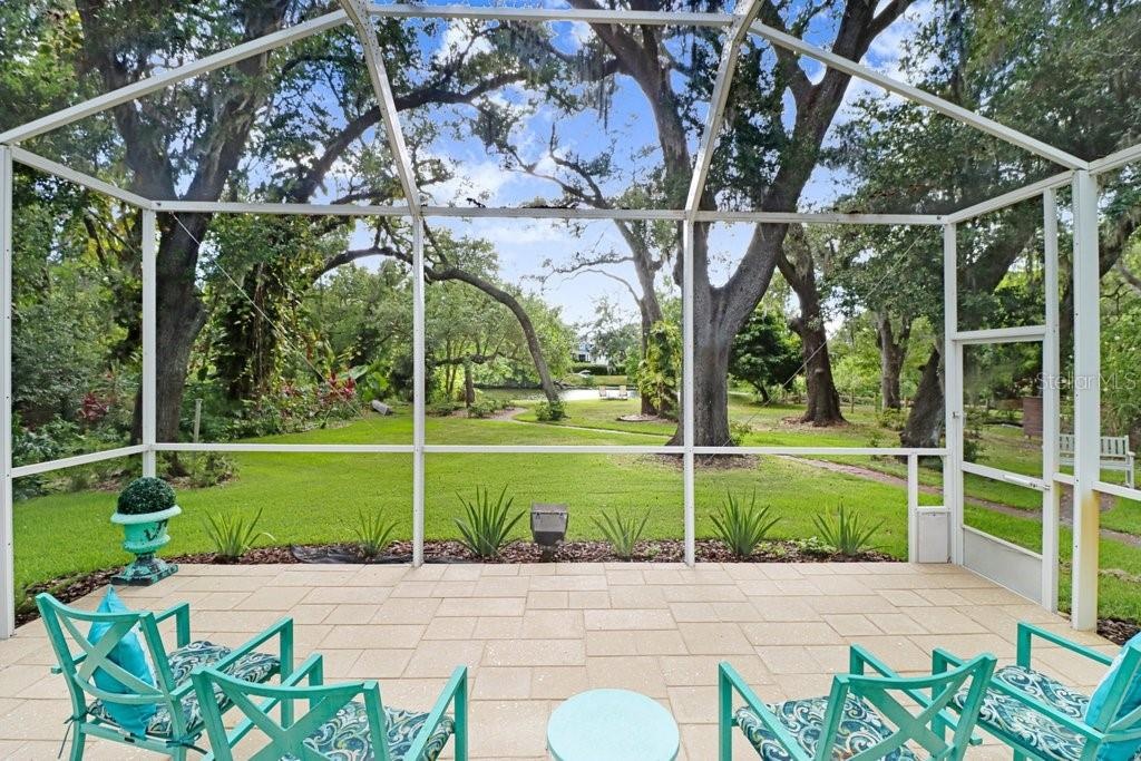 Another view of the step-down patio with backyard mature oaks and walking path to lake area.