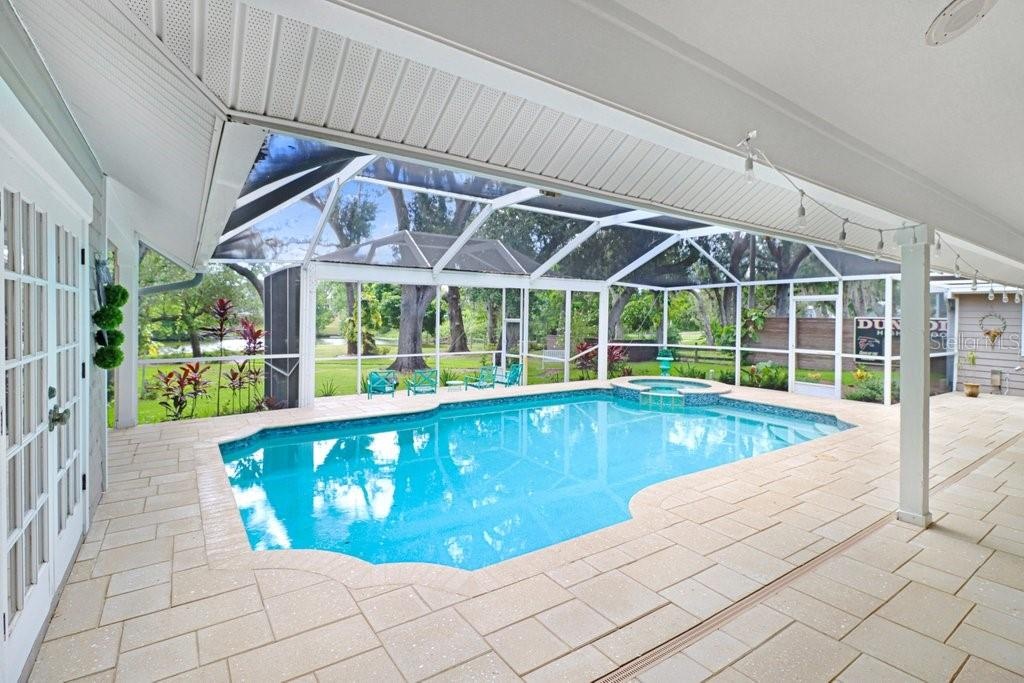 1992 square foot pool/spa/patio area custom pavers and tropical serene views of backyard to lake area.