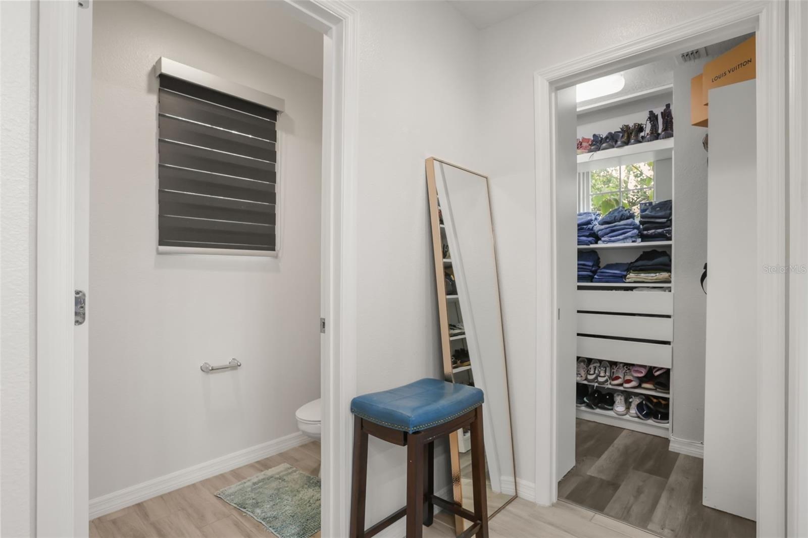 Spacious walk-in closet with custom built-in shelving and drawer storage for optimal organization.