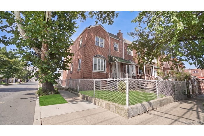 Brick exterior with a prominent bay window, covered front porch, and a fenced front yard