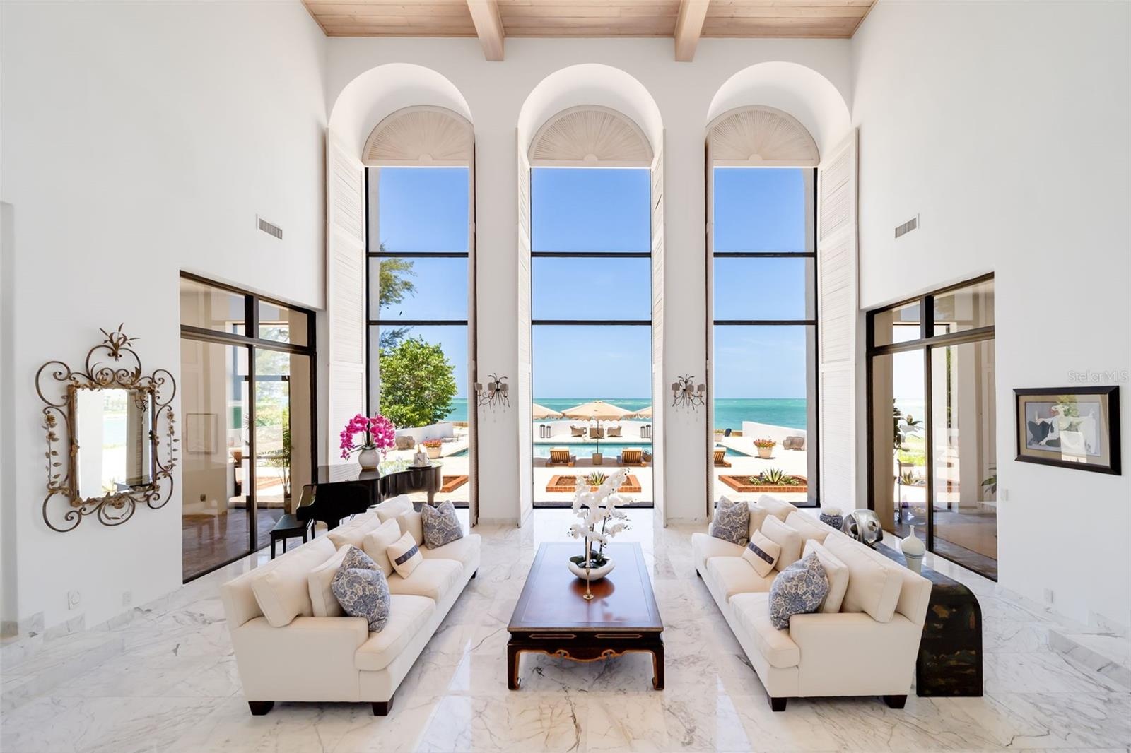 From here the gathering room opens up to the outdoors onto covered and screened terraces overlooking western sunsets.  There are two wet bars in this 