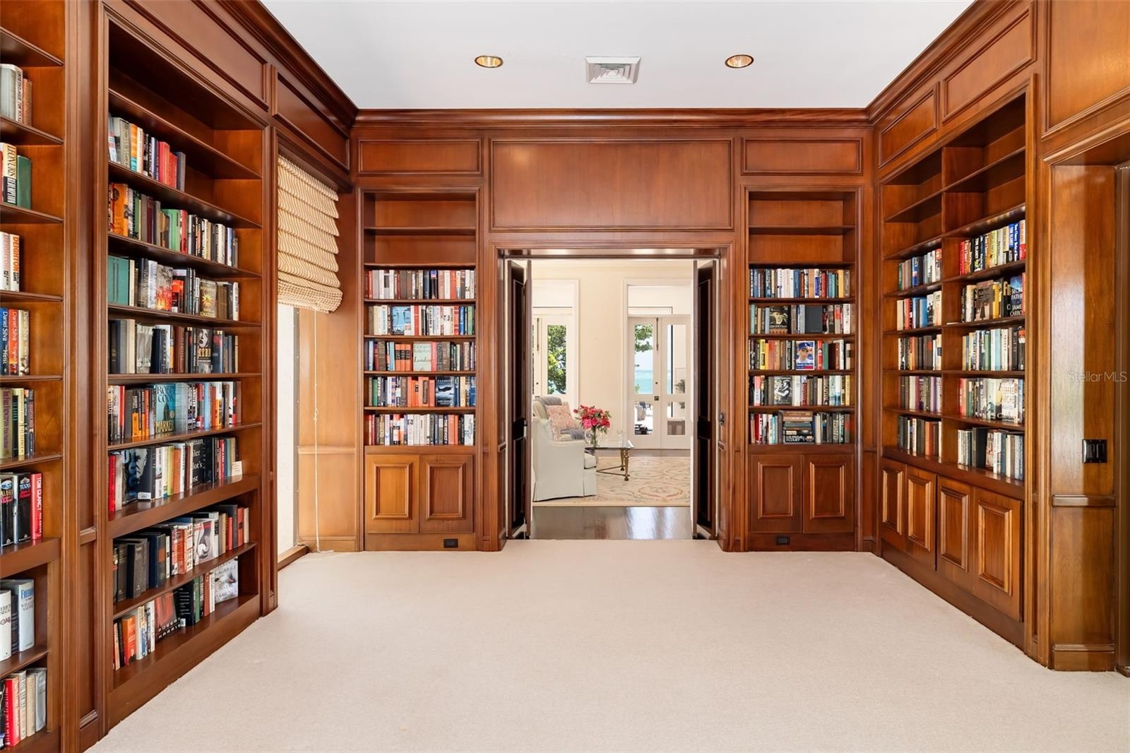 The library with double wooden doors going into the formal living room and on the right doors going into the private family/TV room with built-ins.