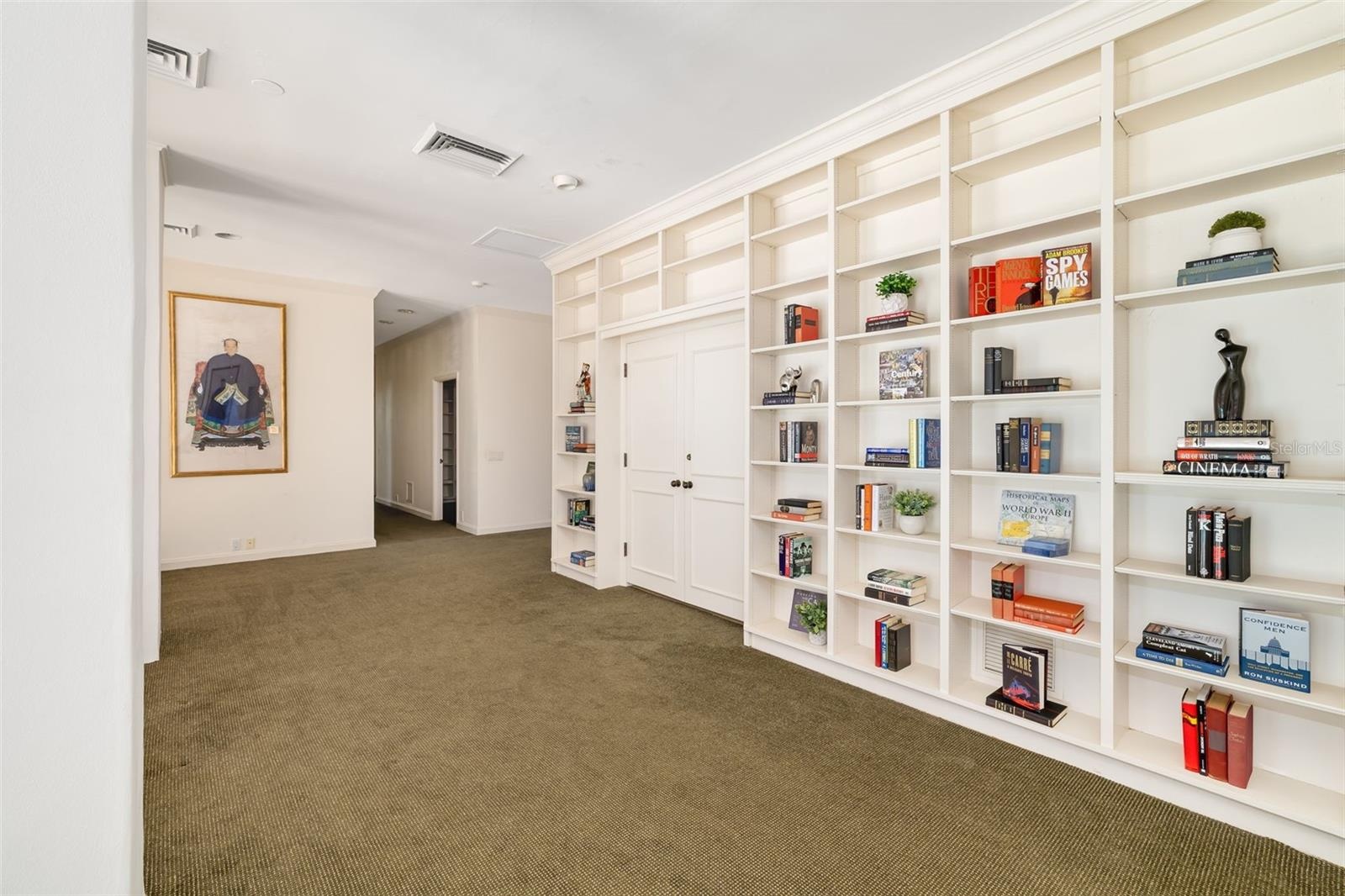Behind the bookshelves the homeowners used this room as an office, however it could be an additional bedroom and the other door shown open was used as
