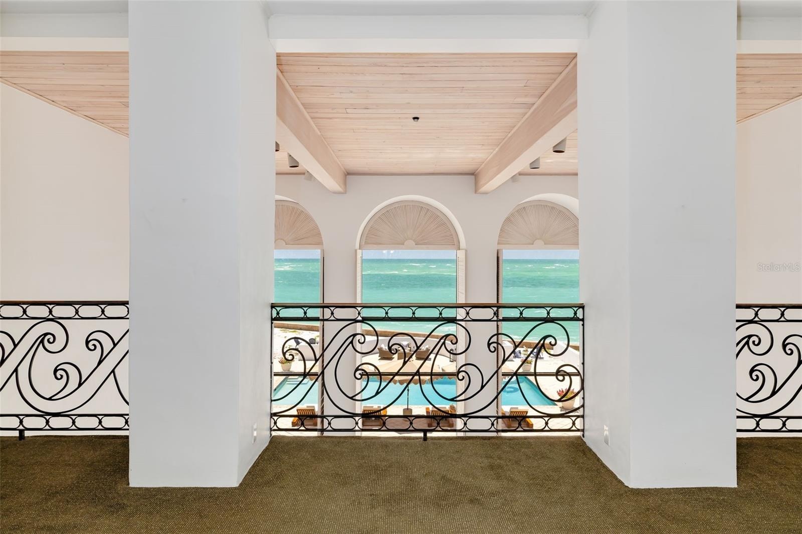 An elegant second-story balcony overlooks the gathering room below, creating a dramatic sense of scale while connecting five upstairs rooms