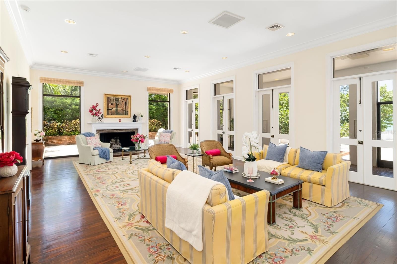 The formal living room with french doors overlooking the ocean and spilling onto a covered and screened terrace overlooking the pool