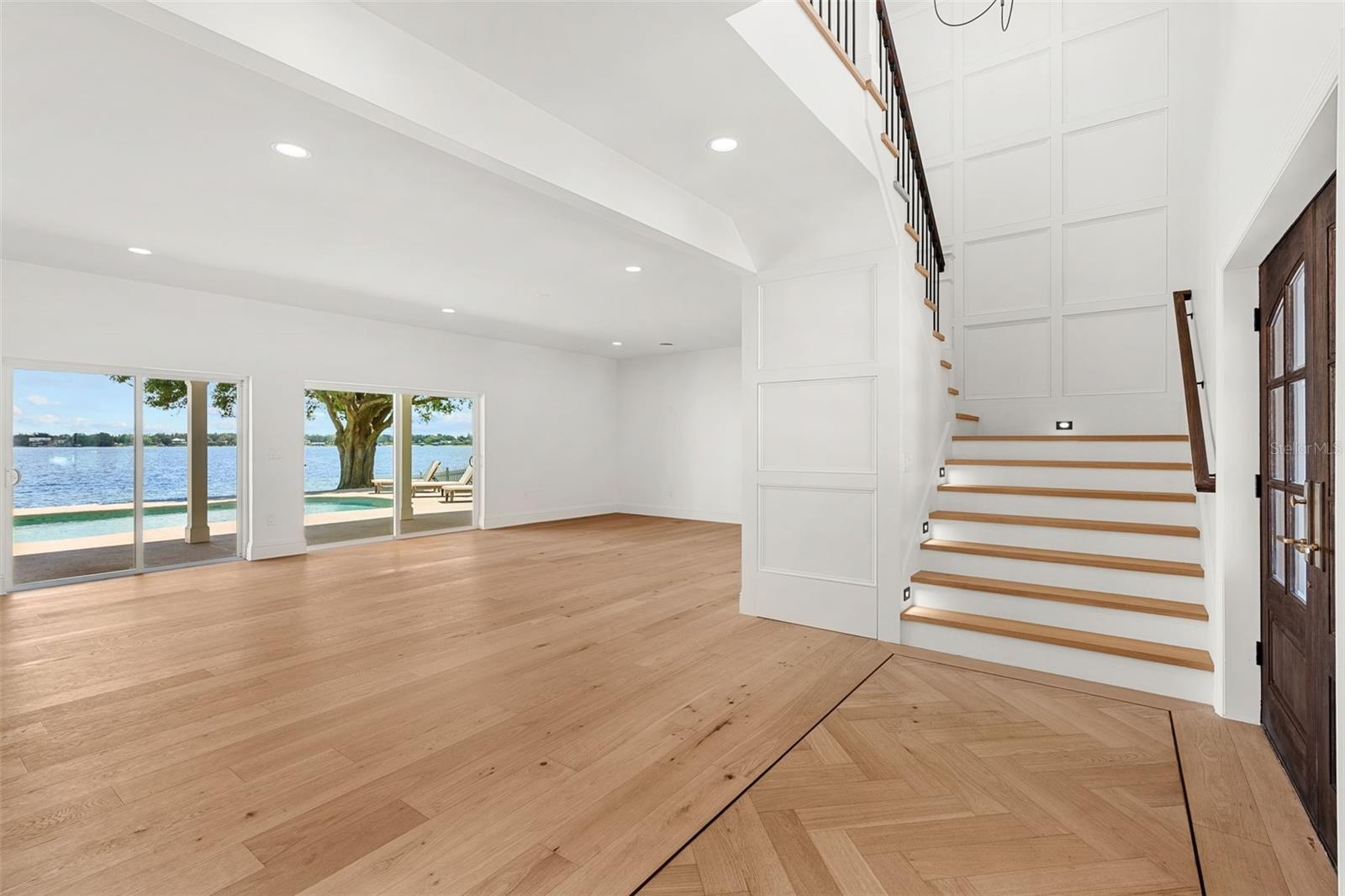 ELEGANT STAIRCASE ASCENDING TO A LOFT SANCTUARY WITH BREATHTAKING BALCONY VIEWS OF LAKE CONWAY