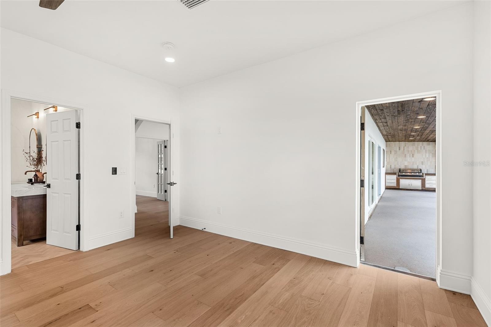 PRIMARY BEDROOM LEADING OUT TO THE POOL AREA.