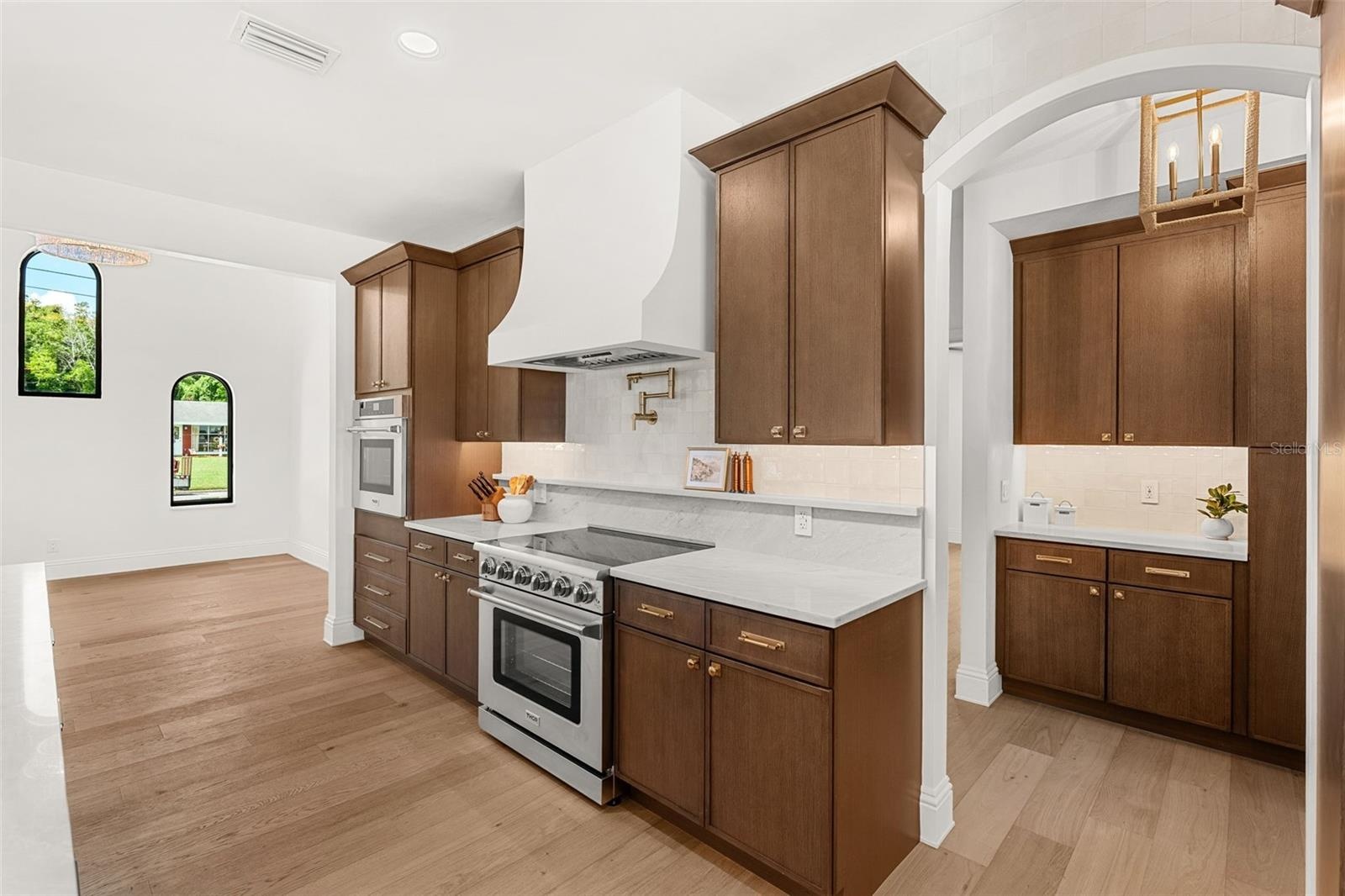 SHOWS THE BUTLERS PANTRY TUCKED RIGHT BEHIND THE KITCHEN, AND A HUGE DINING AREA TO THE SOUTH OF THE KITCHEN FOR PERFECT CONVENIENCE!