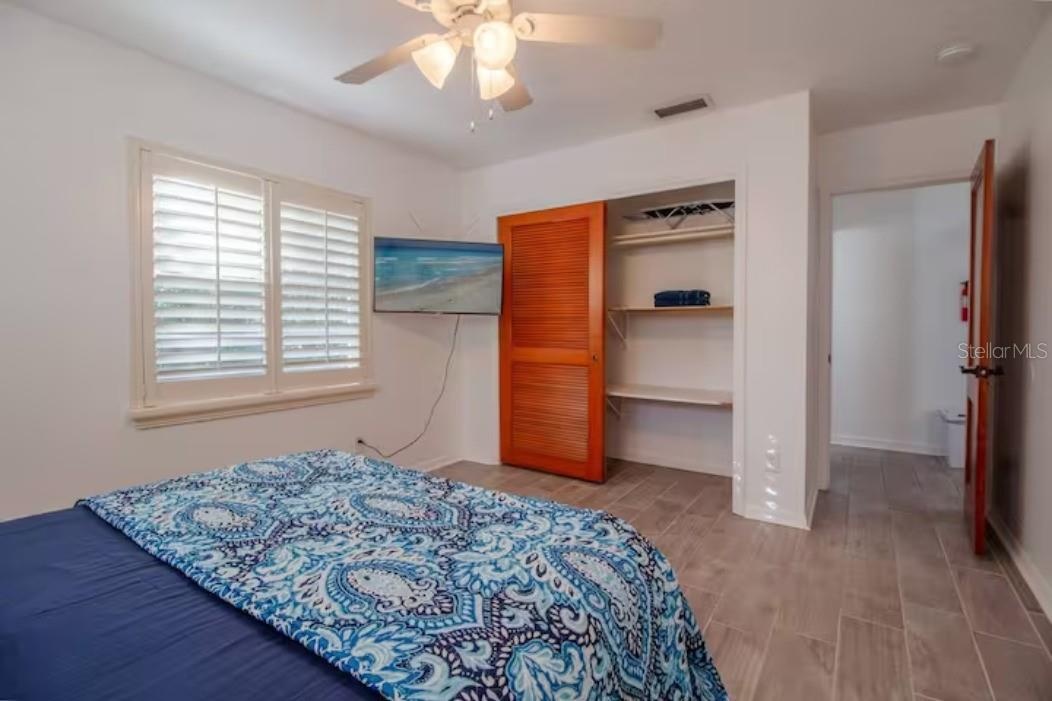 Master with queen bed, tv, ceiling fan, window to the outside, closet, access to the bathroom.