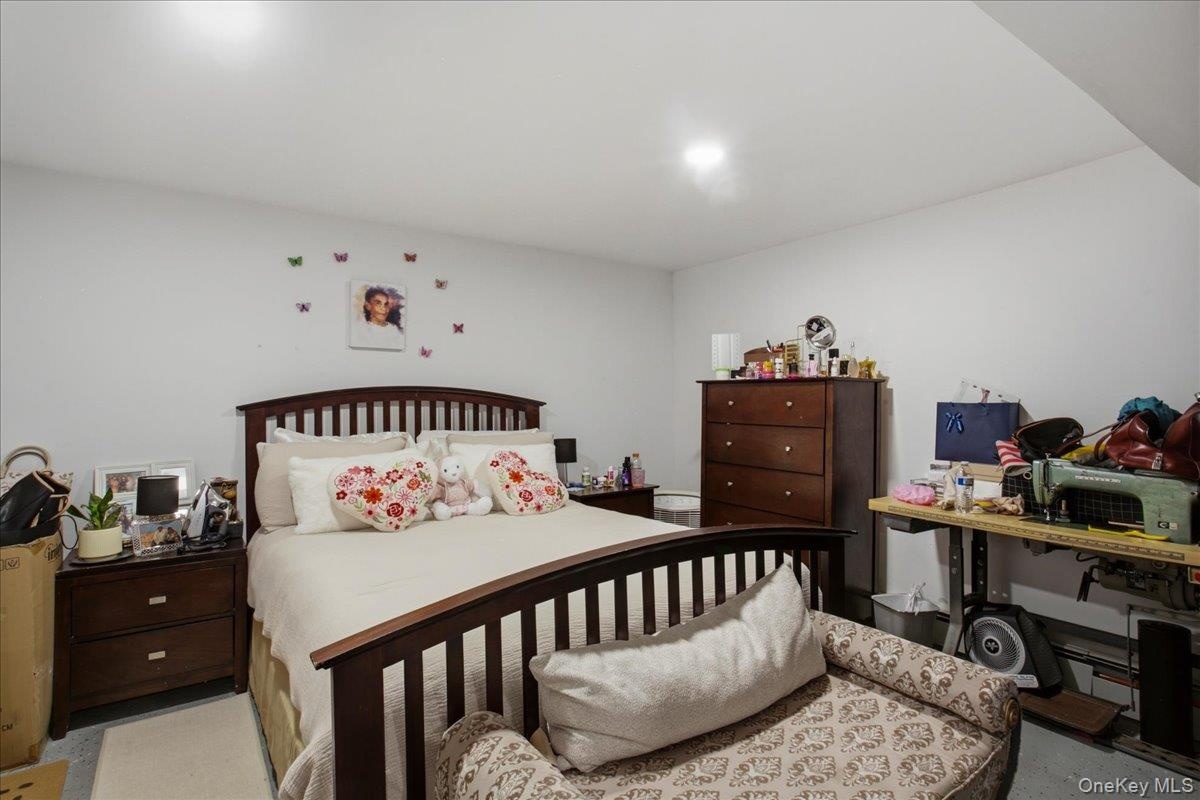 Spacious bedroom and bath on lower level featuring light-toned walls and ceiling, recessed lighting, and durable flooring with a den area with a kitch