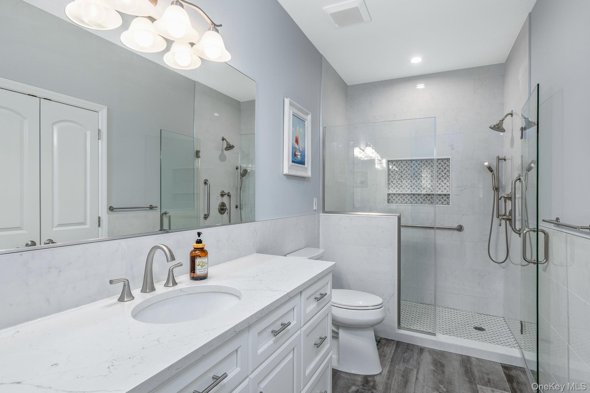 Primary Suite Bathroom featuring a glass-enclosed shower with multiple showerheads