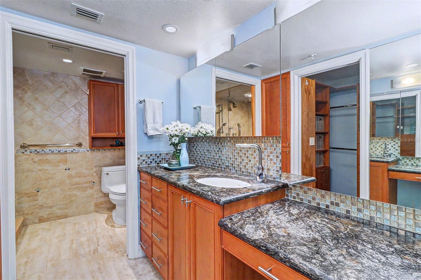 Primary Suite Bath is thoughtfully appointed with separate vanity areas, providing both privacy and convenience, and includes a built-in makeup table 