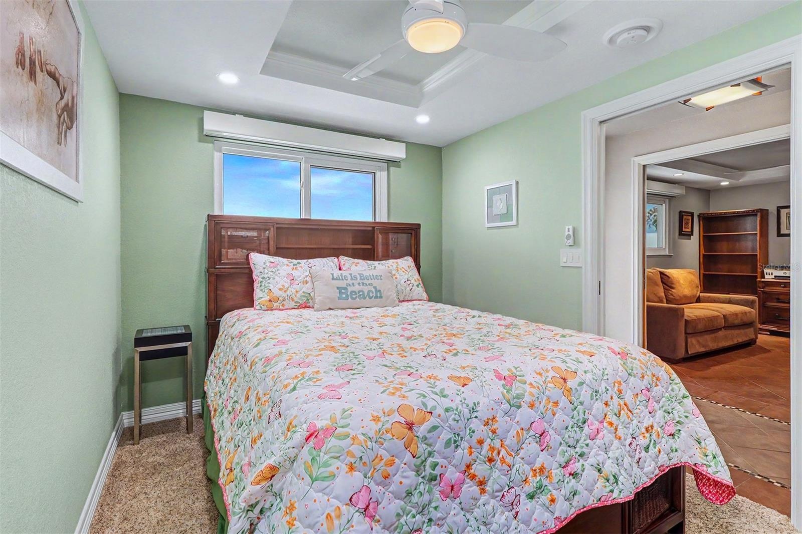 3rd guest bedroom offers a comfortable retreat with a ceiling fan, TV, and built-in closet system for organized storage.