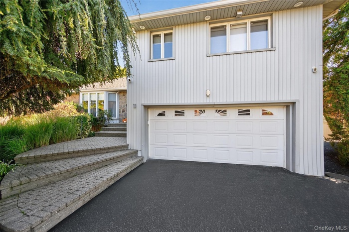 Exterior featuring vertical siding and a two-car garage