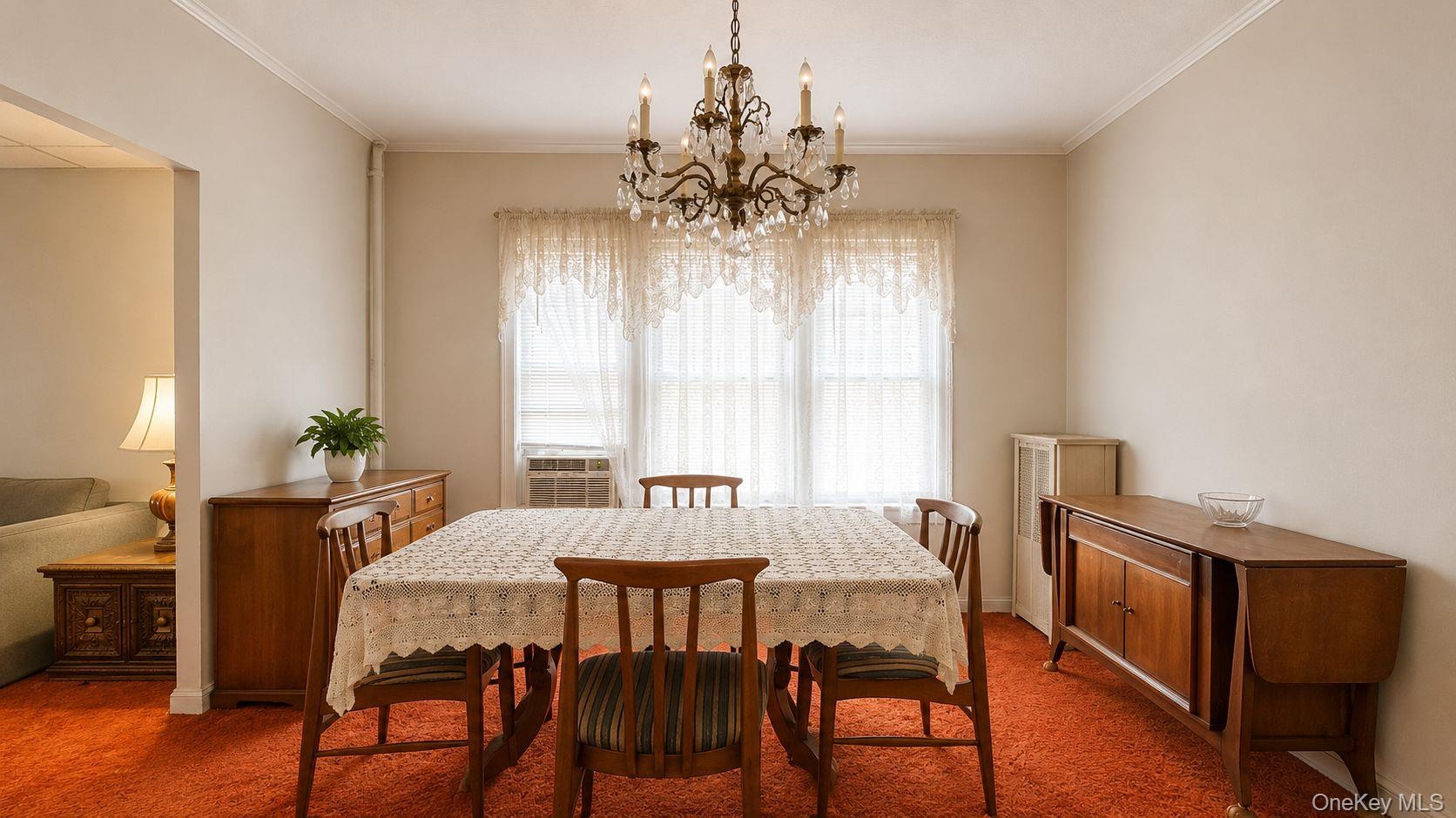 Dining area featuring a crystal chandelier, crown molding, and an accent wall