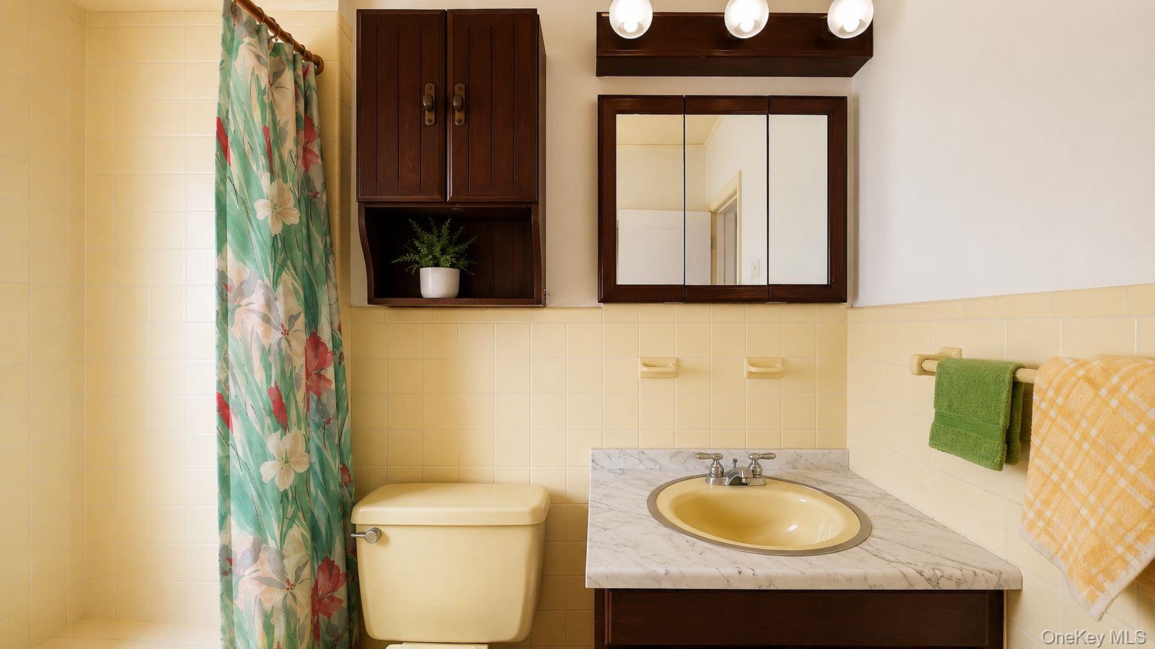 Bathroom featuring a marble-patterned countertop with an oval sink, a wall-mounted medicine cabinet, and overhead vanity lighting