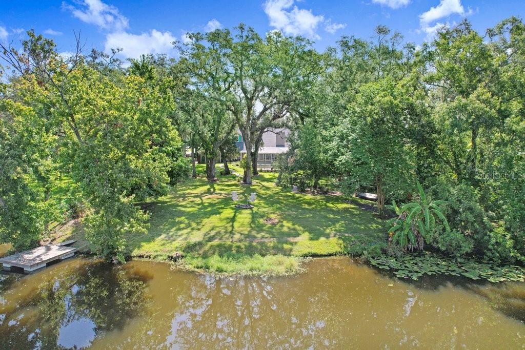 Drone view of back yard, floating dock and fire pit.