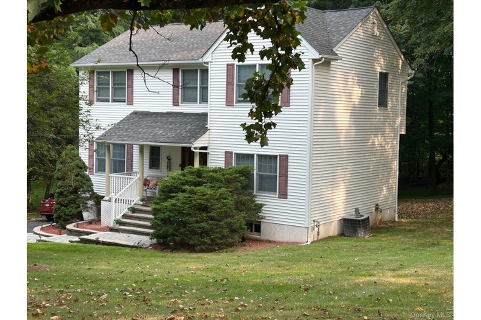 View of front of home featuring a shingled roof, a porch, and a front yard